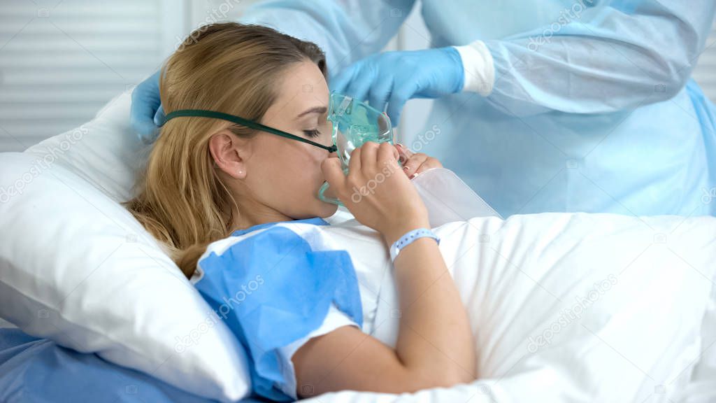 Nurse wearing female patient oxygen mask, preparation before surgery, hospital
