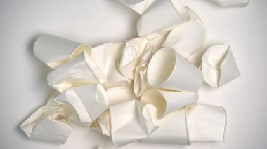 Kullanılan kağıt bardaklar hafif arkaplanda yatıyor, atık sıralama sorunu, ortam