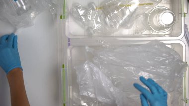 Gönüllü eller fabrikada plastik atıkları, yeniden kullanılabilir malzemelerde sıraya göre sıralayan