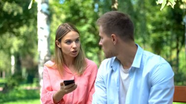 Kızgın kadın kocasına bağırıyor elinde akıllı telefon, ihanet kanıtı, kıskançlık