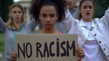 Afroamerikalı kız elinde ırkçılık işareti yok, aktivistler insan hakları sloganı atıyorlar