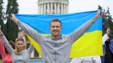 Happy youth raising Ukrainian flag, diaspora in Washington, patriotic nation clipart