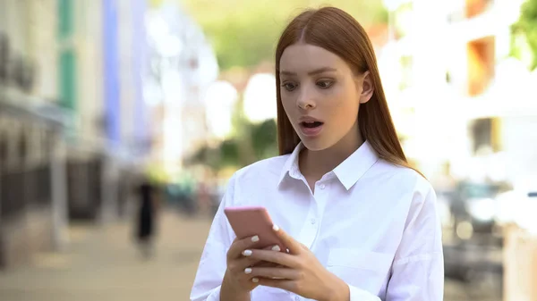 Jovem Ruiva Feminino Rolando Rede Social Smartphone Chocado Com Notícias — Fotografia de Stock