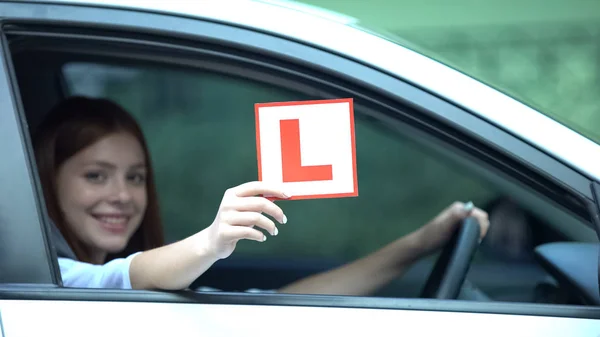 Χαμογελαστό Κορίτσι Δείχνει Plate Στο Παράθυρο Του Αυτοκινήτου Μαθήματα Οδήγησης — Φωτογραφία Αρχείου