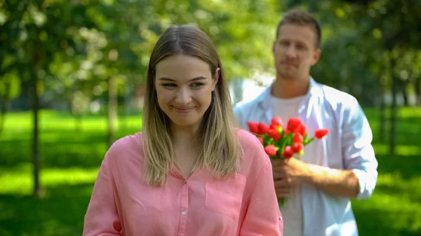 公园里快乐的微笑的女人 身后有花的男朋友 约会邀请 — 图库照片