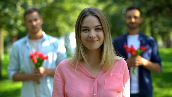 Mujer Joven Feliz Con Dos Admiradores Sosteniendo Flores Fondo Elección —  Fotos de Stock