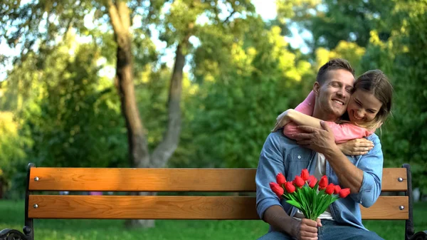 Happy Young Woman Hugging Boyfriend Holding Red Tulips Hands Outdoor — Stock Photo, Image