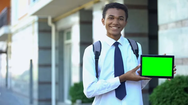 緑色の画面のタブレット 教育アプリを示す笑顔の混合レース高校生 — ストック写真