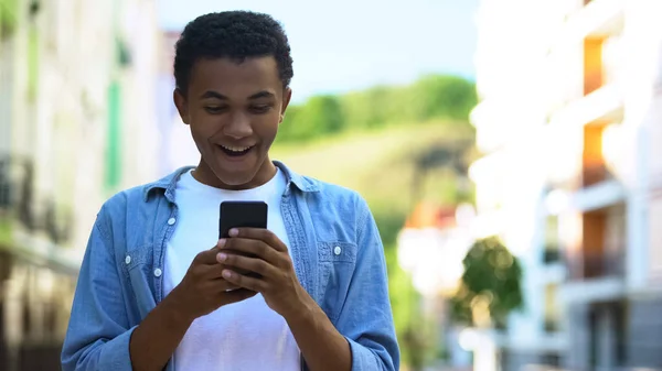 Adolescent Entuziasmat Zâmbind Citind Mesaj Despre Vânzări Reduceri Smartphone — Fotografie, imagine de stoc