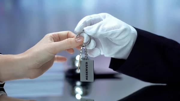 Male Hand Giving Lady Keychain Word Reserved Luxury Service Hospitality — Stock Photo, Image