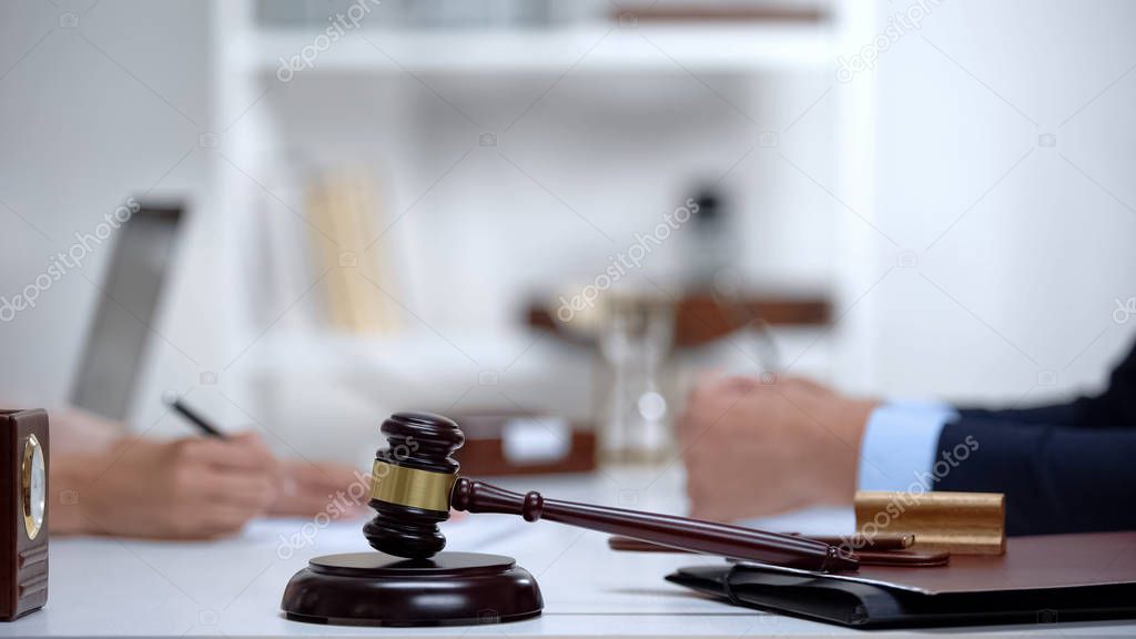 Gavel and block on table, woman meeting lawyer on background, notarial services
