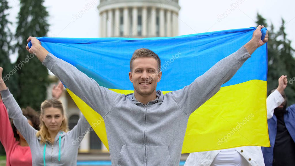 Happy youth raising Ukrainian flag, diaspora in Washington, patriotic nation