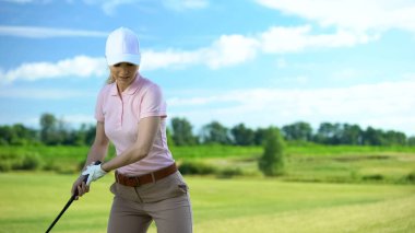 Golf kursuna, antrenmana ve spora gitmeyi hedefleyen genç bir kadın.