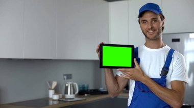 Tamirci yeşil ekranlı tableti, bakım işini ve servisi gösteriyor.