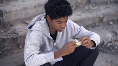 Mutsuz siyah erkek elinde dolar banknotları, mali kriz, sorun