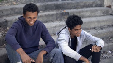 Gülümseyen Afro-Amerikalı gençler esrar içiyor ve ergenlik çağında eğleniyorlar.