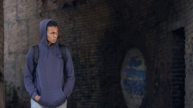 Üzgün siyah ergen yalnız başına yürüyor terk edilmiş bina, yalnızlık, sorun