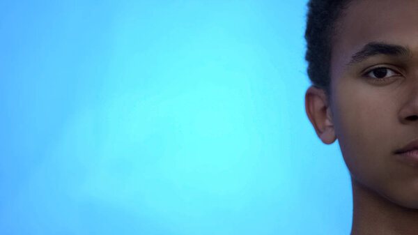 Серьезный африканский американский подросток смотрит в камеру, проблемы с расизмом, издевательства
