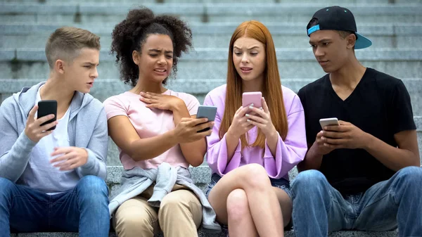 Female student showing friends disgusting video by smartphone app, internet