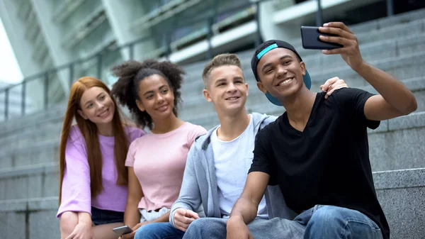 年轻的多种族青少年通过智能手机的应用自拍 玩得很开心 — 图库照片
