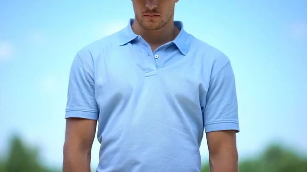 青いTシャツの憂うつな男悲しいことに 屋外を見下ろして絶望的な感じ — ストック写真
