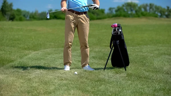 鉄クラブを保持するゴルフコーチ ボールを打つ準備 近くのスポーツ用品袋 — ストック写真