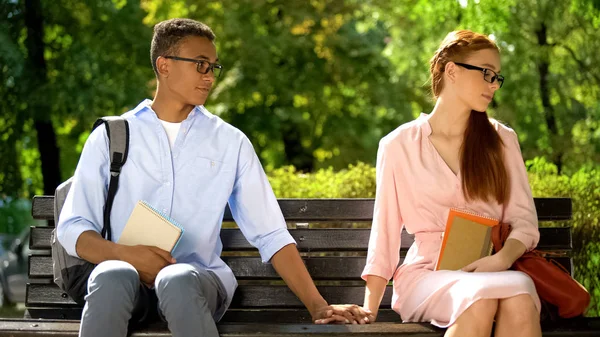 Studenti Multirazziali Che Tengono Mano Seduti Sulla Panchina Del Parco — Foto Stock