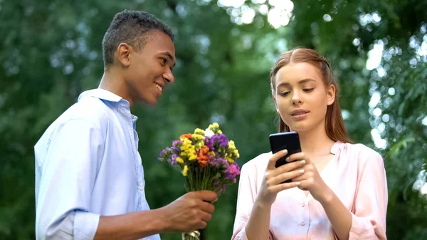 Likgiltig Tonåring Flicka Ignorerar Pojkvän Presentera Blommor Chatta Smartphone — Stockfoto