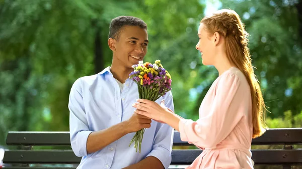 Sorrindo Mestiço Adolescente Menino Apresentando Flores Amadas Menina Primeiro Encontro — Fotografia de Stock