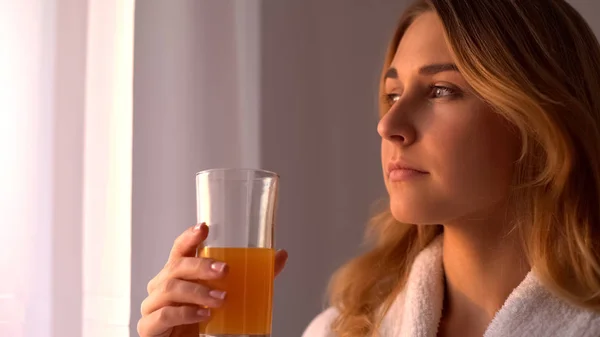 Nainen Jolla Appelsiinimehua Katselee Ikkunasta Vitamiineja Iholle Terveellinen Juoma — kuvapankkivalokuva