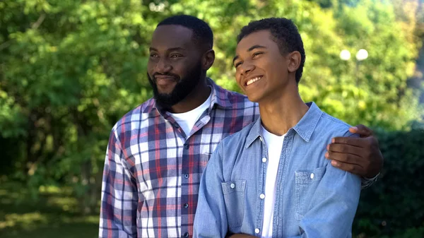 Happy Afro American Dad Hugging Teenage Son Standing Outdoors Together — ストック写真