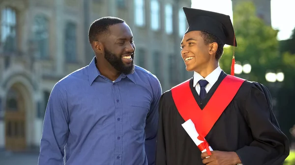Sorridente Padre Nero Abbracciando Figlio Laureato Con Diploma Grado Istruzione — Foto Stock