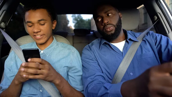 Iloinen Afroamerikkalainen Teini Kutoma Puhelin Isä Yrittää Lukea Viestin Ajon — kuvapankkivalokuva