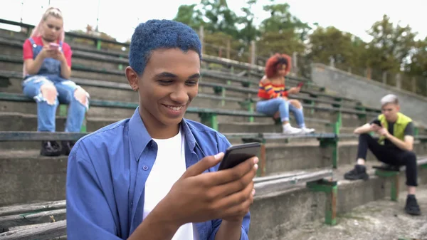 Smiling Male Student Chatting Smartphone App Classmates Phones Background — Stock Photo, Image