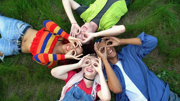 Jóvenes Felices Mostrando Buen Gesto Como Prismáticos Tumbados Campus Parque — Foto de Stock