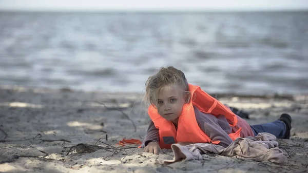 少女は命のジャケットを着て海岸に横たわって 生き残った飛行機の墜落事故 — ストック写真
