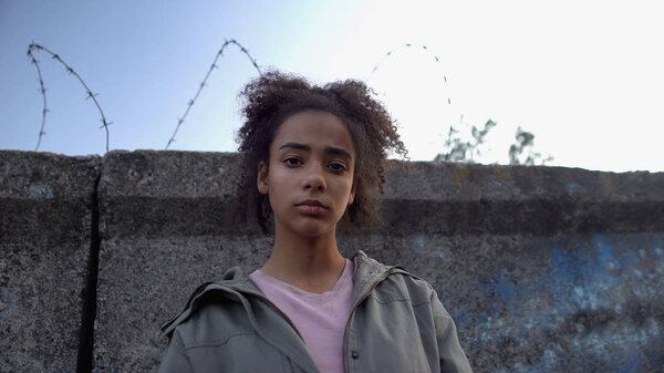 Девочка-подросток смотрит в камеру, мечтает сбежать из тюрьмы, малолетняя преступность

