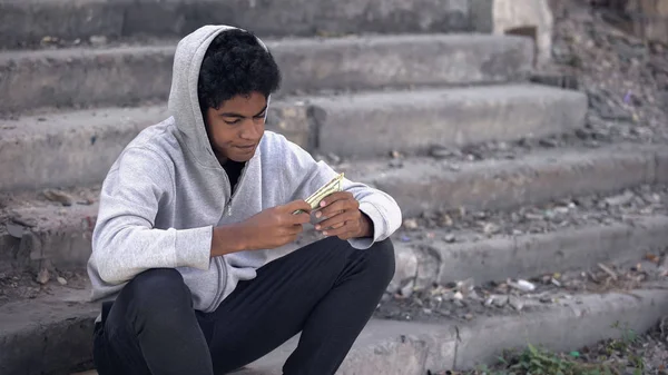失望的黑人年轻人想到钱一个人坐在楼梯上 — 图库照片