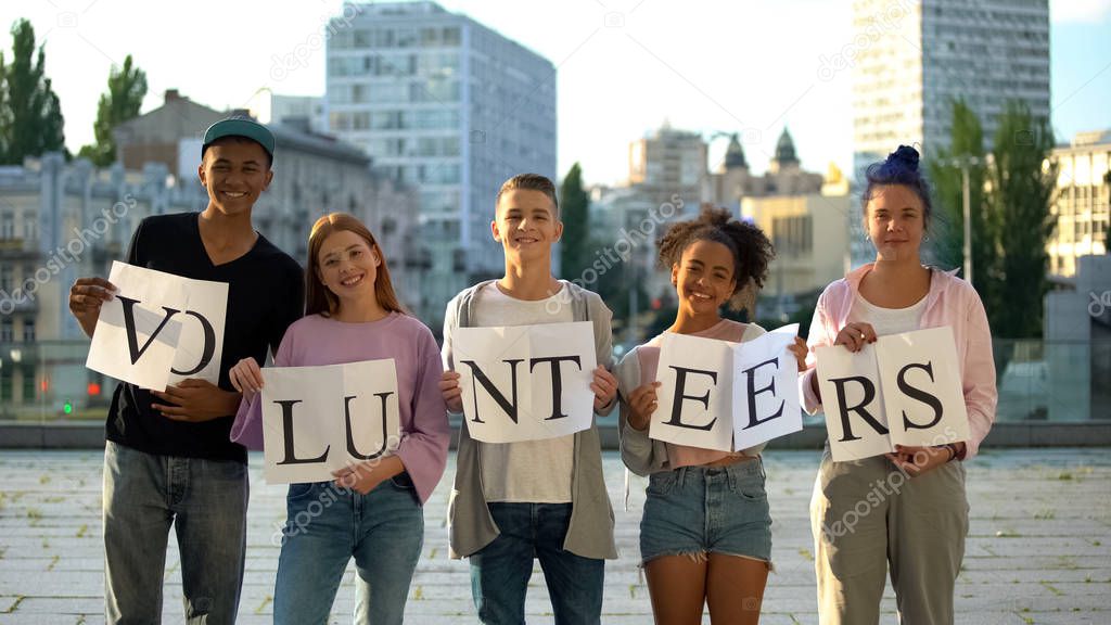 Happy group teenagers holding volunteers sign, social project, charity kindness