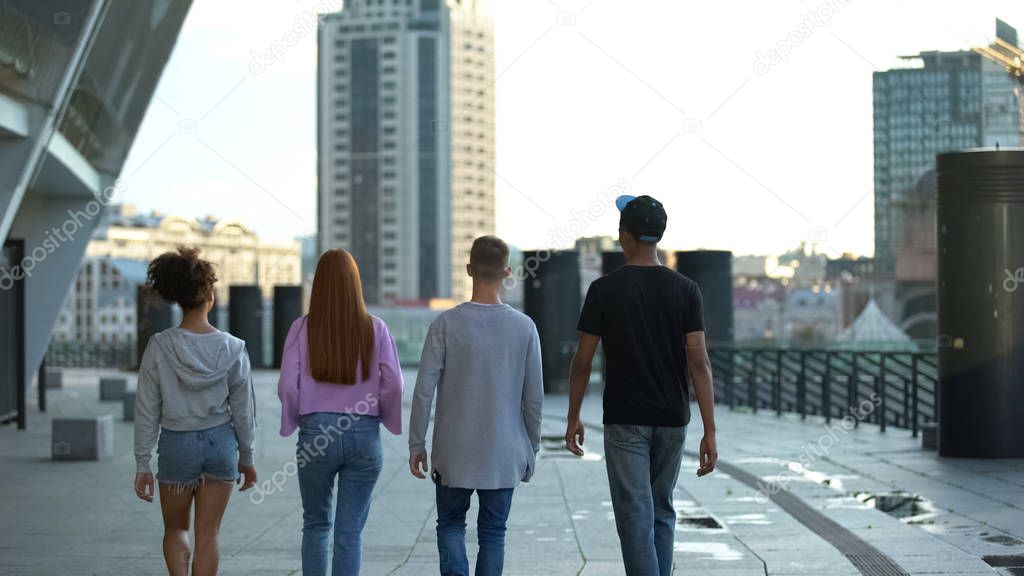 Stylish millennial walking city street together, teenage unity, togetherness