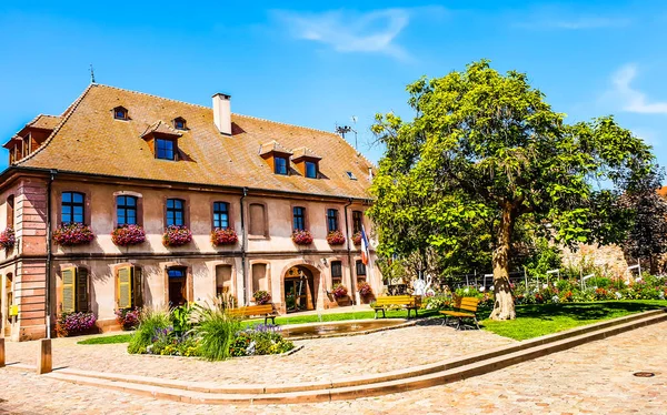 An old stylish village with a tree and blue sky in background