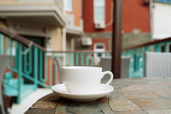 Bílý Porcelánový Čaj Pohár Stole Pouliční Kavárny Domy Pozadí — Stock fotografie