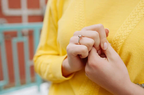 若い女性は顔を持っていません黄色のセーターとホワイトゴールドの婚約指輪で彼女の指 選択的な焦点 — ストック写真