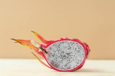 Yarı kırmızı sulu ejderha meyveli pitaya bej bej arkaplanda beyaz et, yiyecek minimalizmi eğilimi, seçici odaklanma