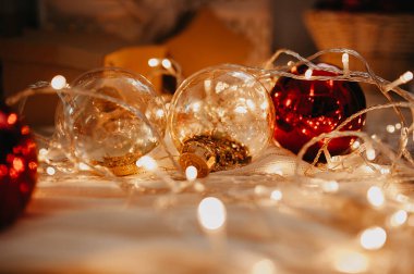 Soyut Noel ve Yeni Yıl ağacı dekoru kırmızı ve altın sarısı yakın plan, çelenkler ve sıcak ışık ışıkları