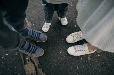 Baba büyüklüğünde üç çift ayakkabı. Anne, orta ve kız. Küçük çocuk bedeninde.