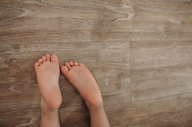 Tahta zeminde çocukların çıplak topukları.