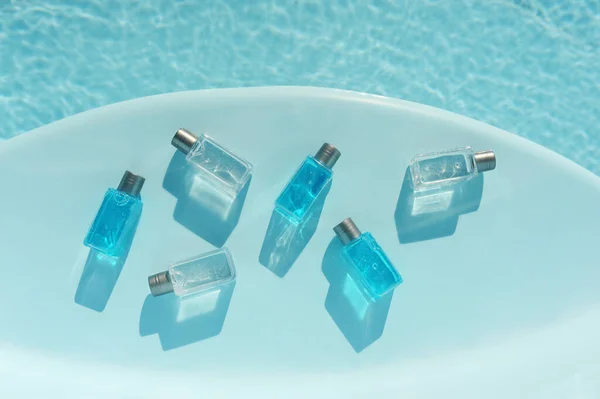 cosmetic jars with blue and white gel on semicircular podium by the water in natural light and hard shadows ,cosmetics advertising, selective focus