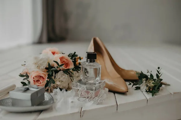 結婚式のためにドレスアップ花嫁のためのアクセサリー ベージュの特許革の靴 香水と光のインテリアで小さなバラのかわいいスタイリッシュな花束 — ストック写真