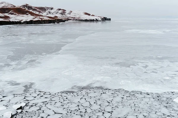 cold sea, covered with unusual small round icicles, melting ice on the sea, the sharp edge of the ice is bordered by flowing water